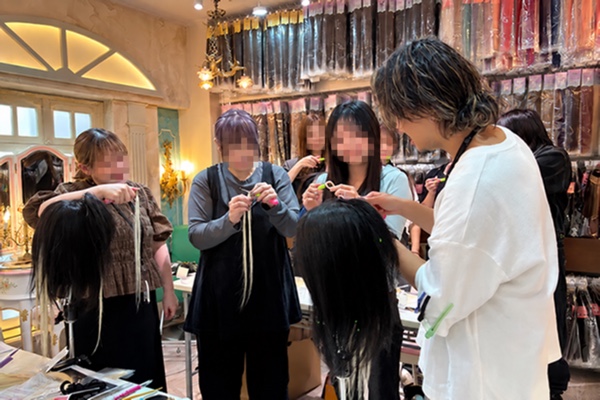 笑顔でエクステの技術を学ぶ受講生と講師